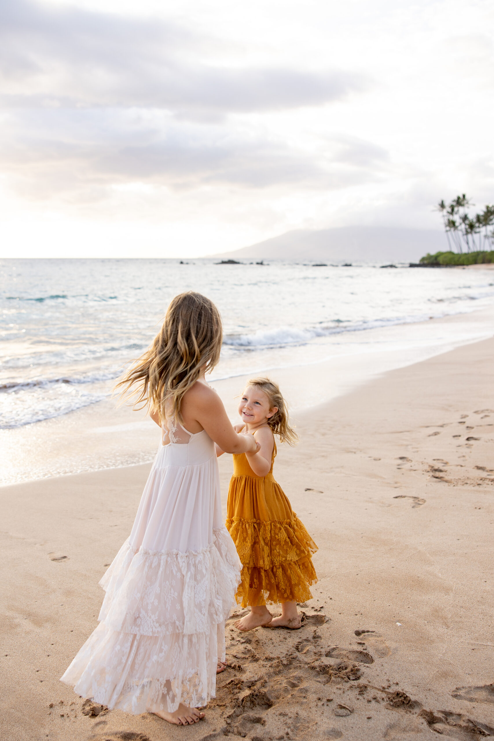 Maui Family Photographer captures mother and daughter playing in sand during maui family photos