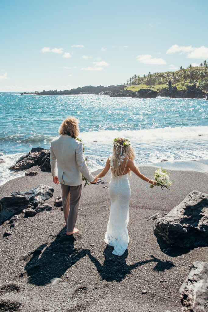 Maui Elopement Photographer captures bride and groom walking towards ocean