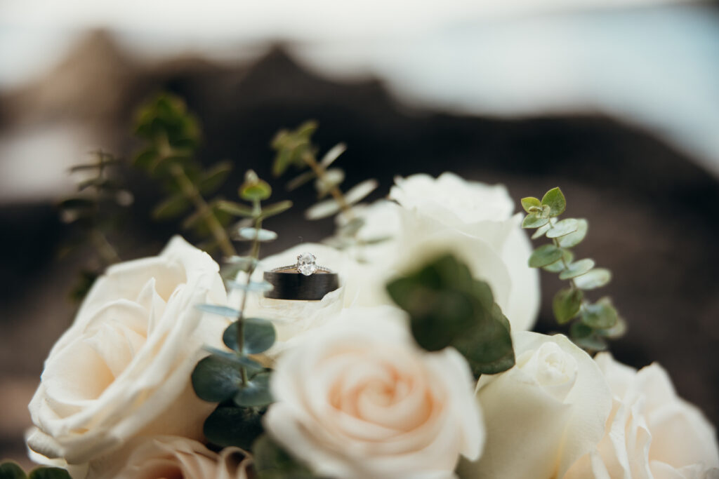 Maui elopement photographer captures wedding rings sitting in bouquet after Hawaii beach wedding