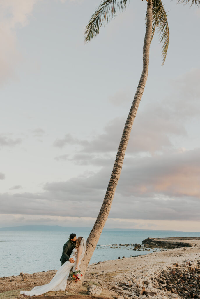 Maui Elopement Photographer captures couple leaning against palm tree during outdoor bridals