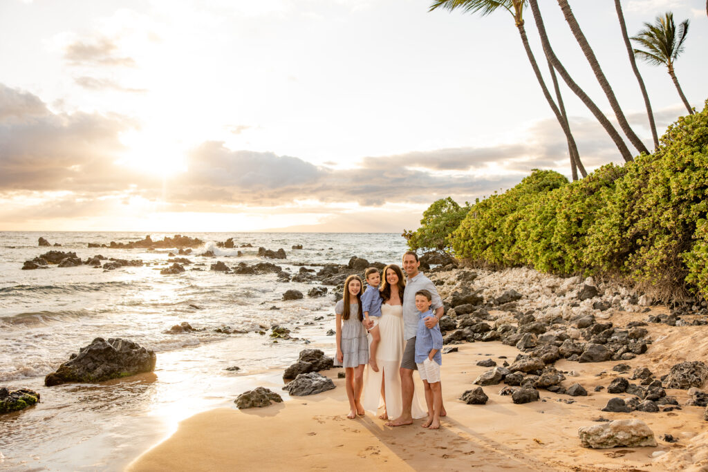 Maui Family Photographer captures young family on beach with ocean beside them