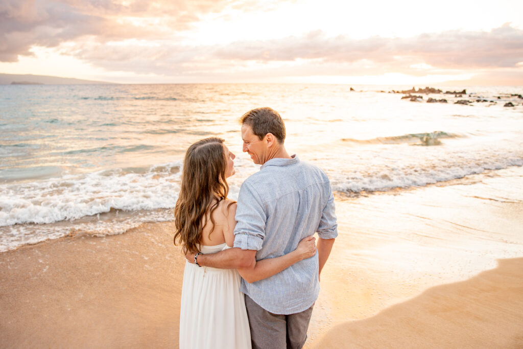 Maui Family Photographer captures mother and father embracing while enjoying oceanside sunset