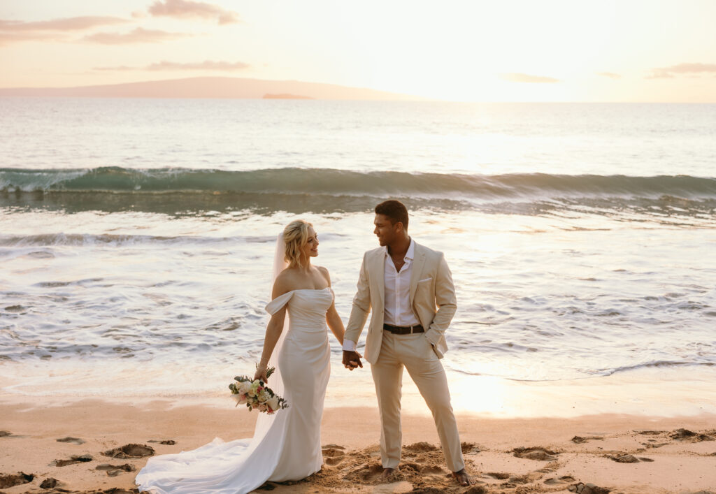 Maui Wedding Photographer captures couple holding hands on the beach during Hawaii beach wedding