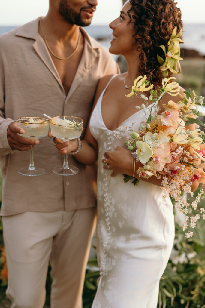 Maui Elopement Photographer captures bride and gorom holding drinks 
