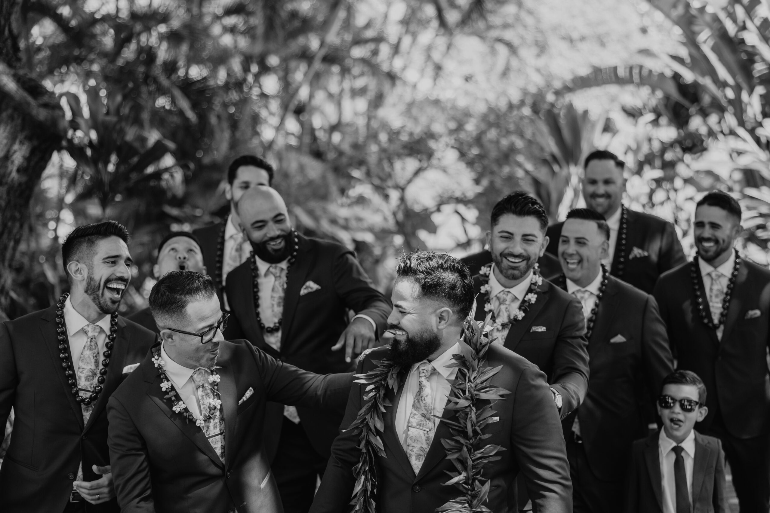 Groomsmen laughing and having fun together, celebrating the big day in a lush, tropical setting full of energy and aloha.
