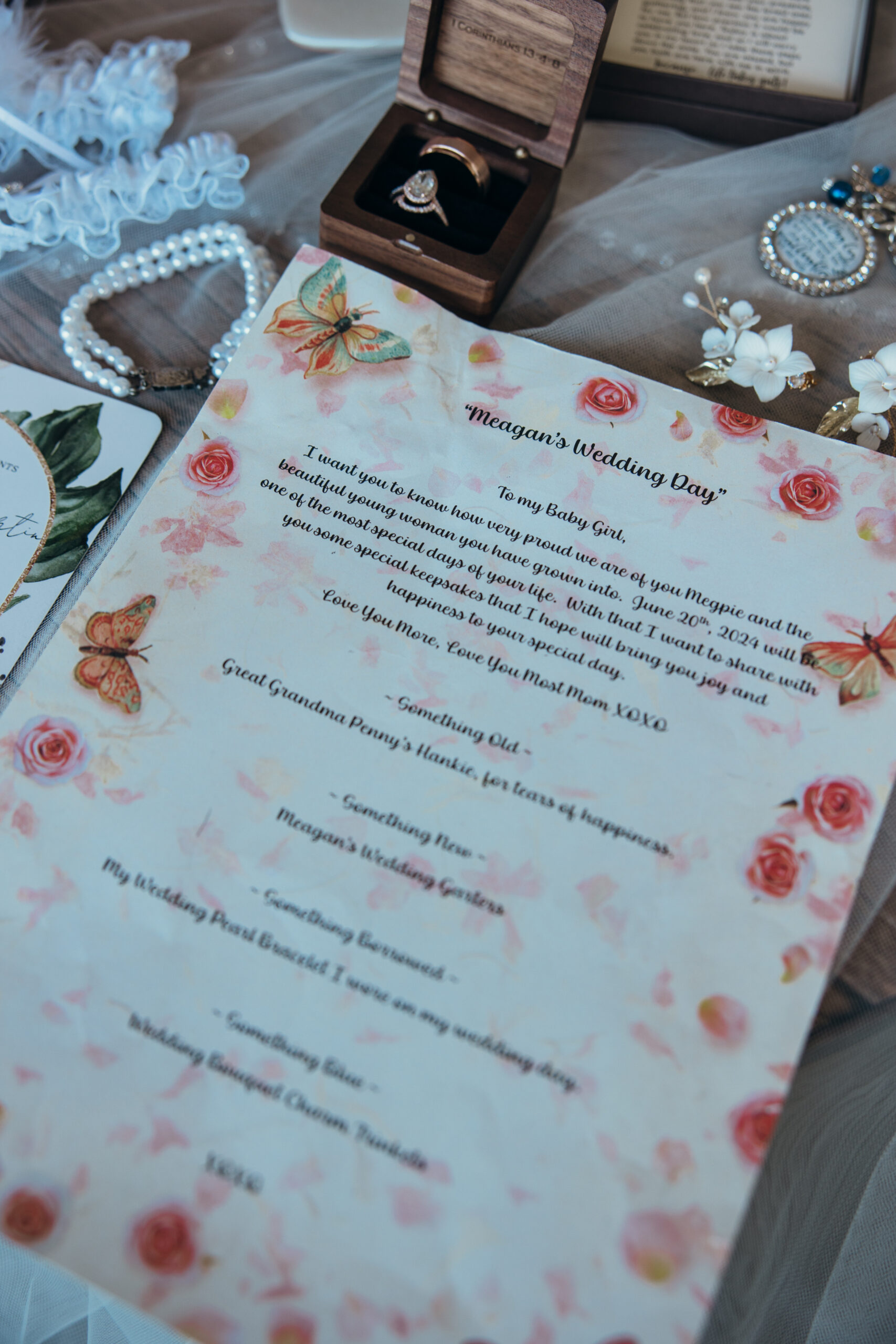 Flat lay of a heartfelt wedding day letter surrounded by bridal details including rings, lace, pearls, and vintage accessories.