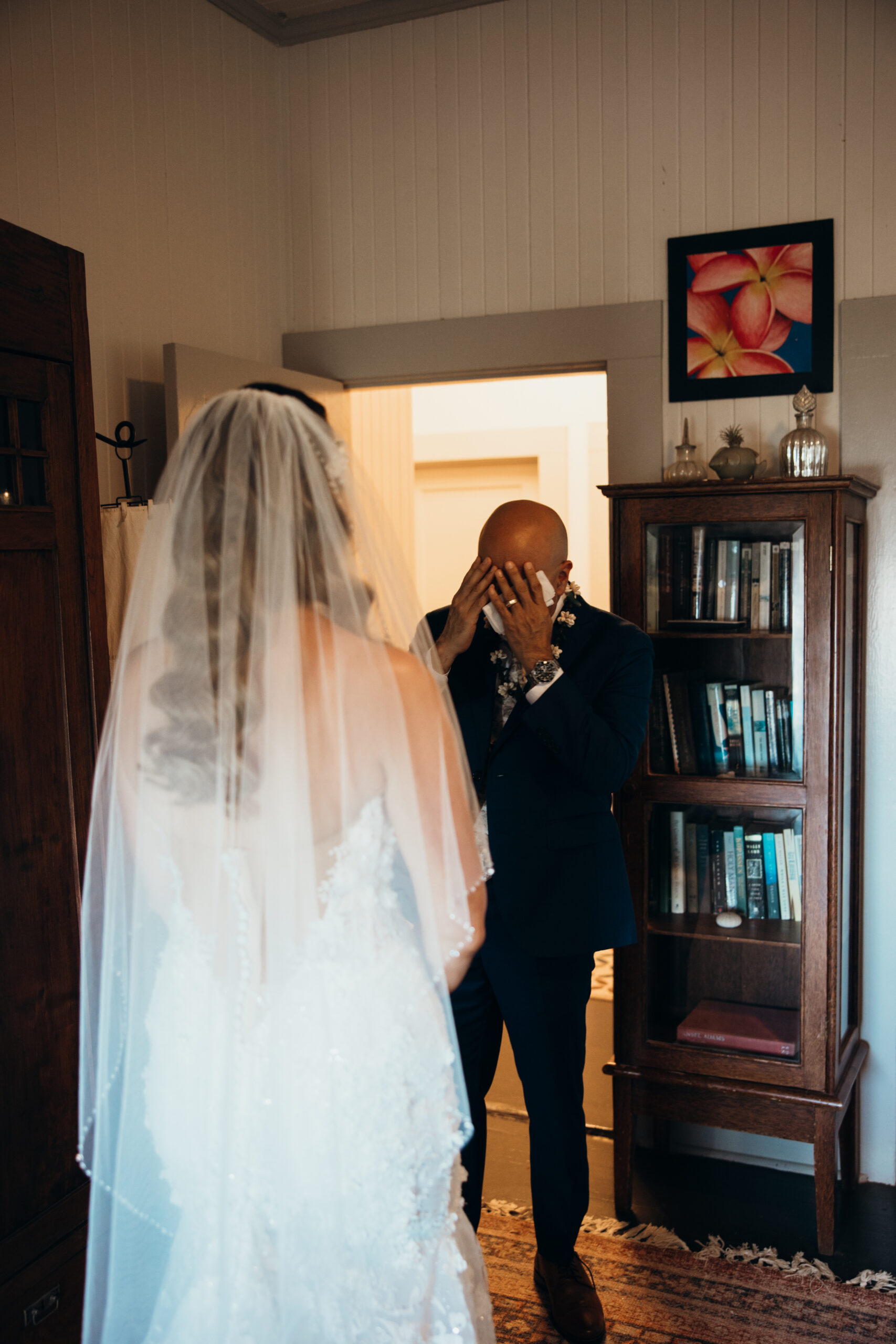 Father wipes away tears after seeing his daughter in her wedding dress during their emotional first look inside a Maui wedding venue.