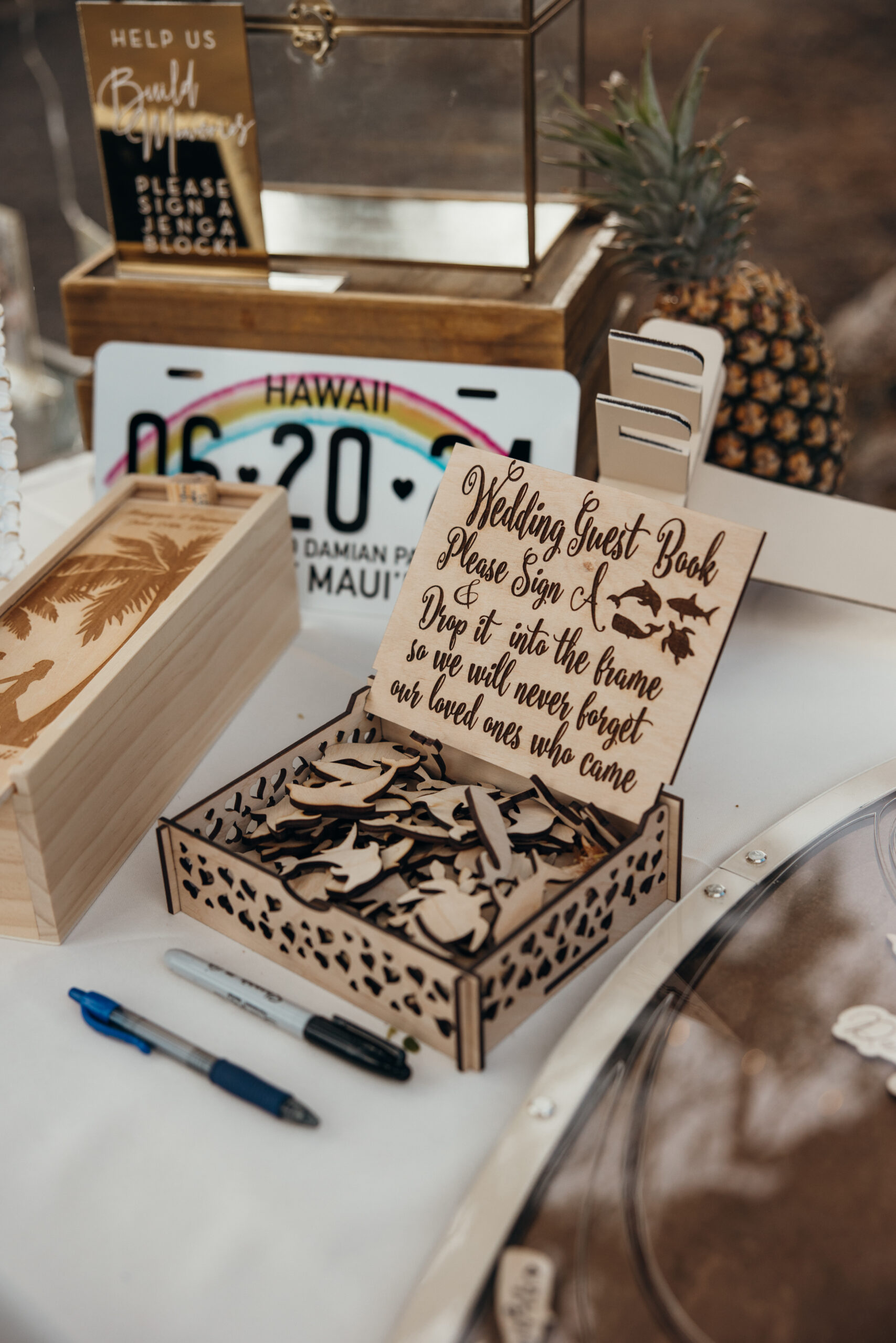 Unique wooden guest book station with Hawaii-themed details, where guests drop signed surfboards into a custom frame.
