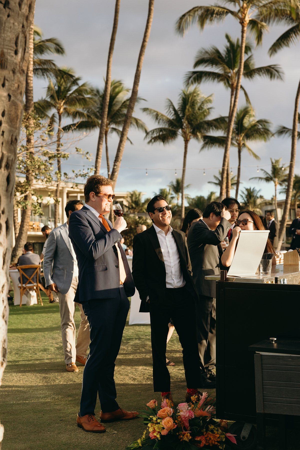 Guests enjoying drinks and conversation at outdoor cocktail hour at tropical resort wedding venue