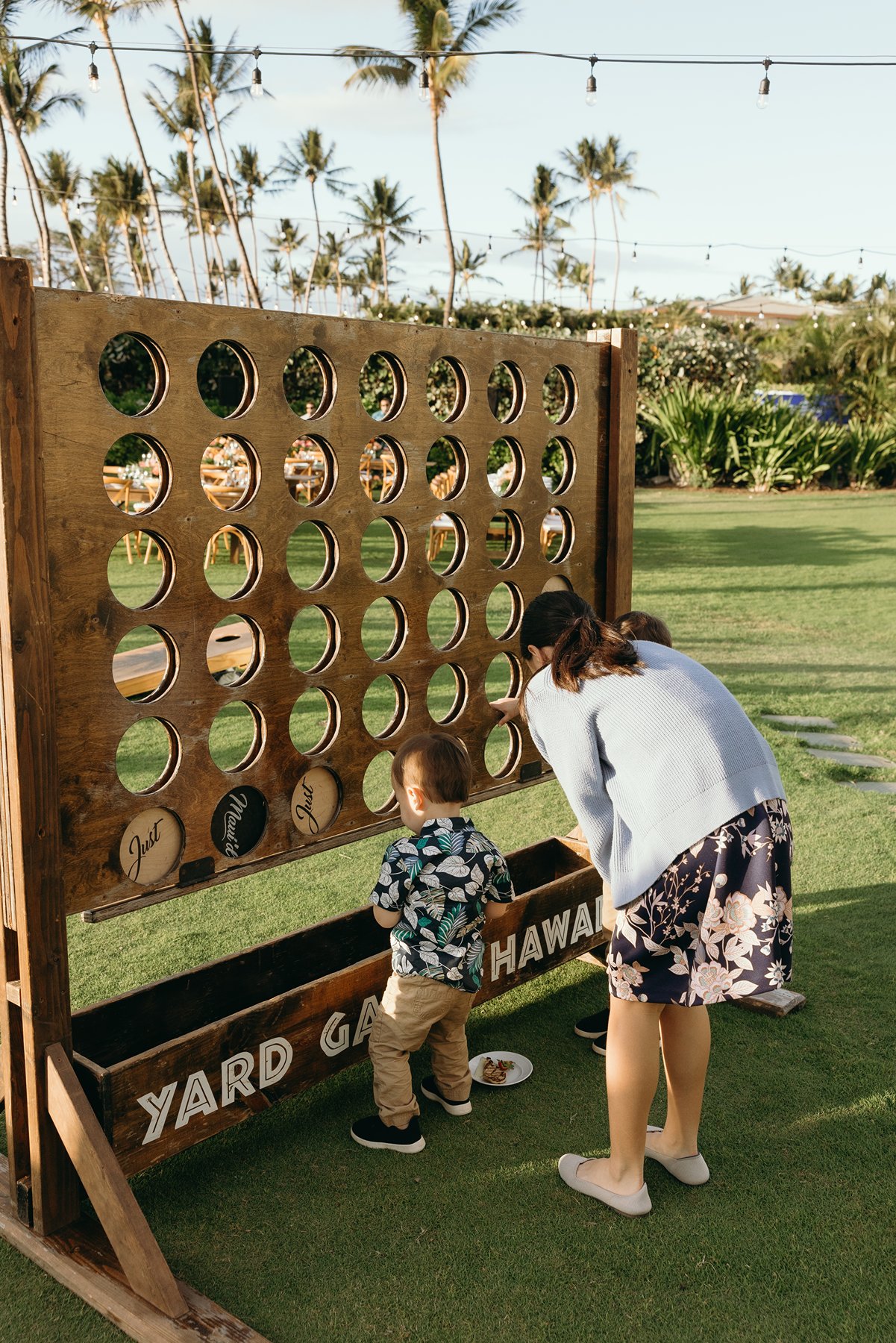 Wedding guests playing lawn games during reception at Maui resort wedding venue