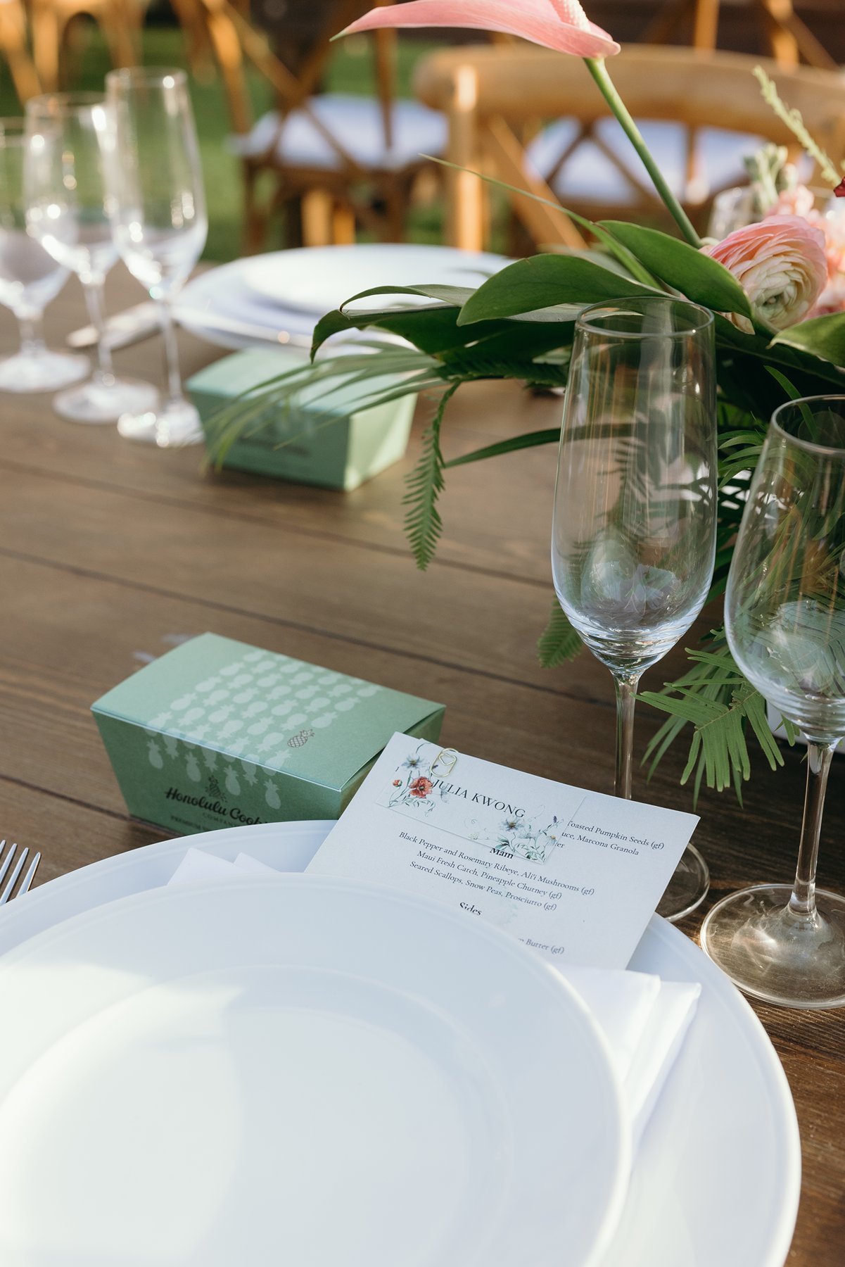 Elegant wedding table details with floral centerpiece, glassware, and place settings at outdoor reception