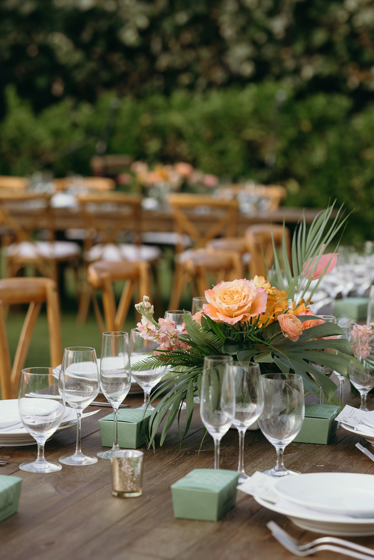 Close-up of tropical floral centerpiece and table setting at outdoor Hawaii wedding reception