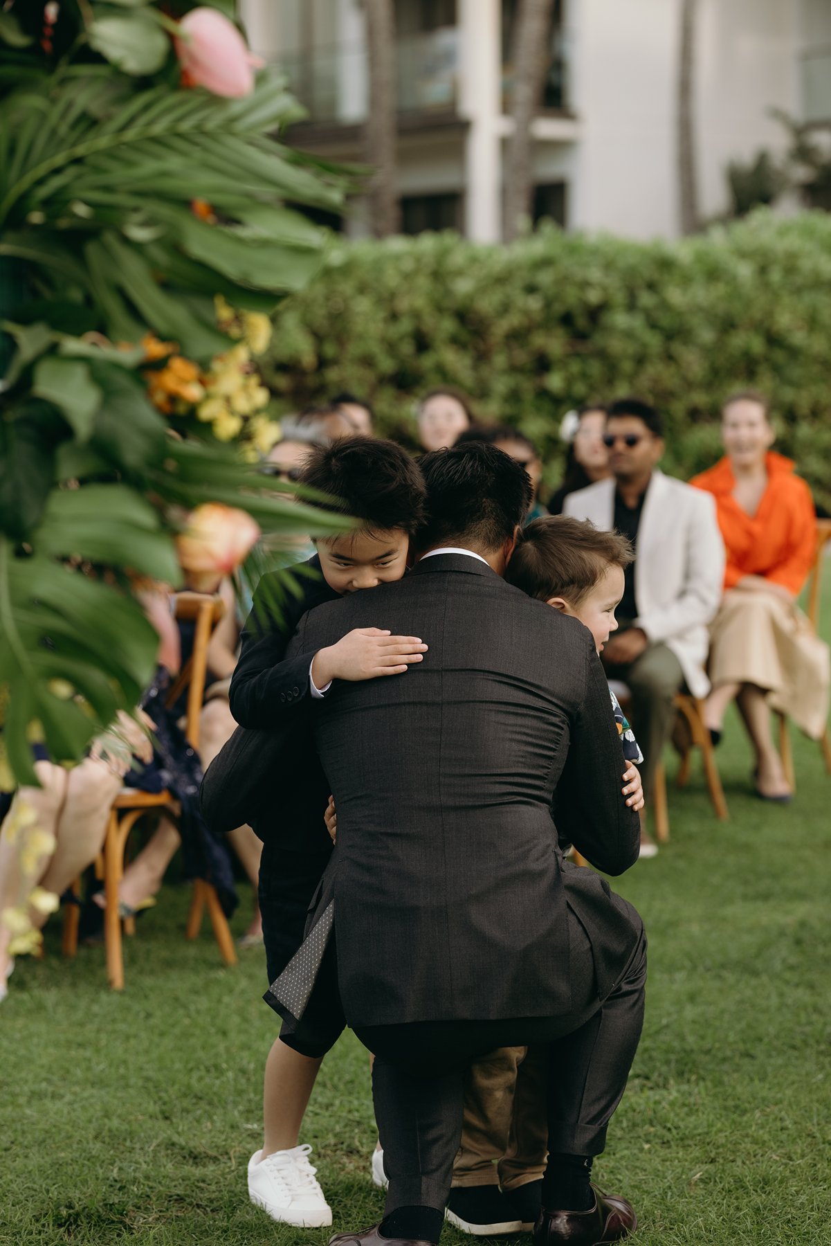 Groom walking down aisle with family member at tropical resort wedding venue ceremony