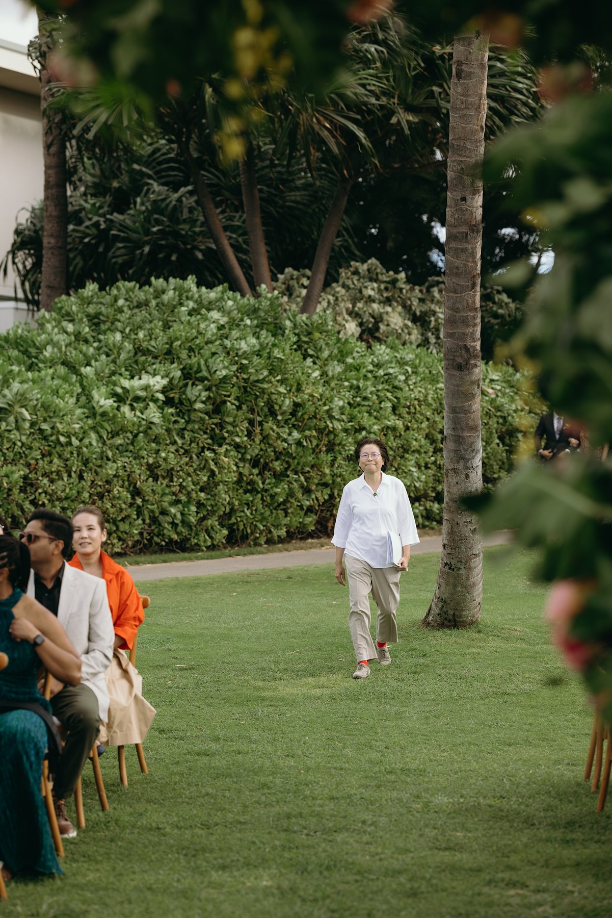 Wedding guest walking down aisle before ceremony begins at outdoor Hawaii wedding
