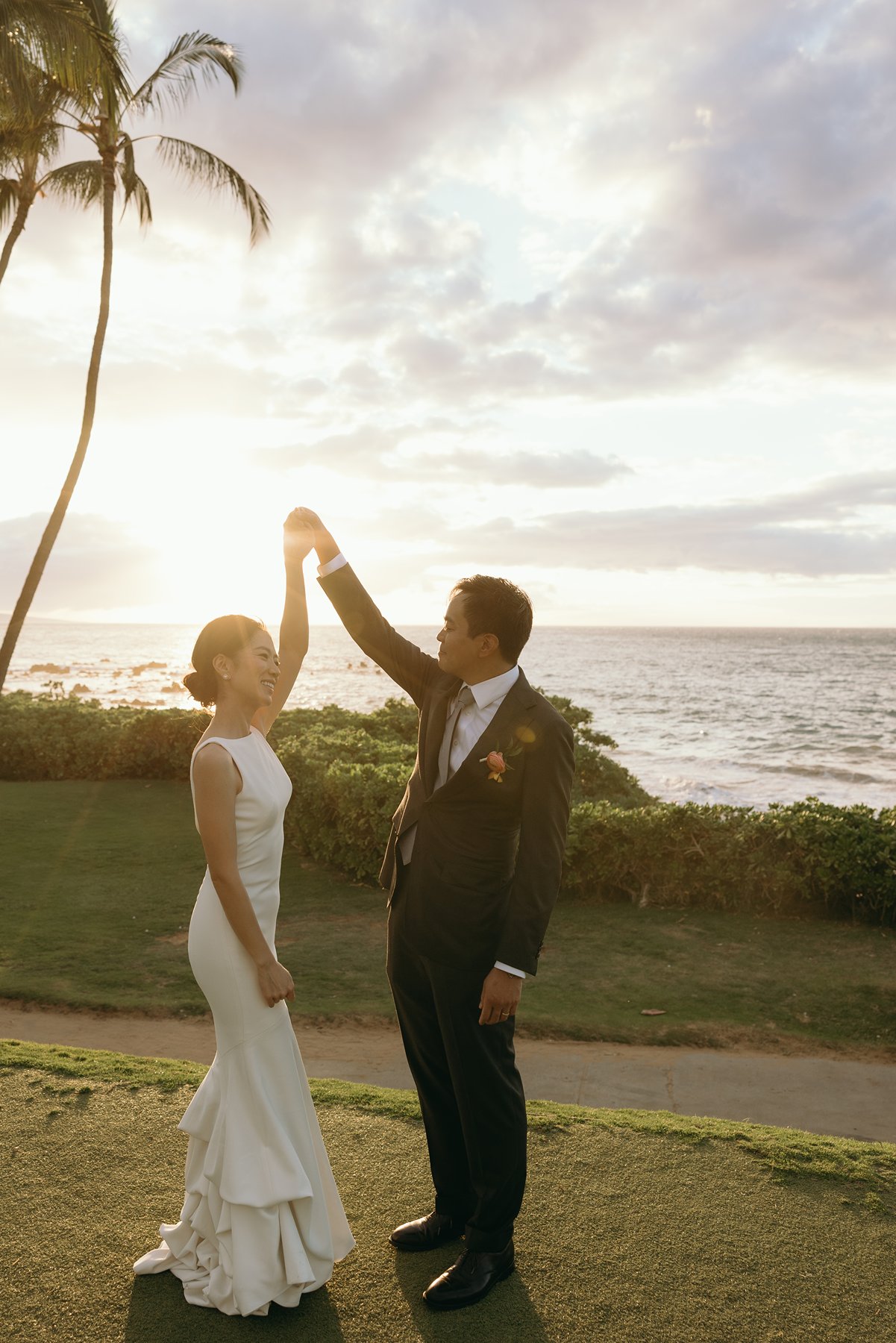 Groom twirling bride at golden hour with ocean backdrop at Maui resort wedding venue