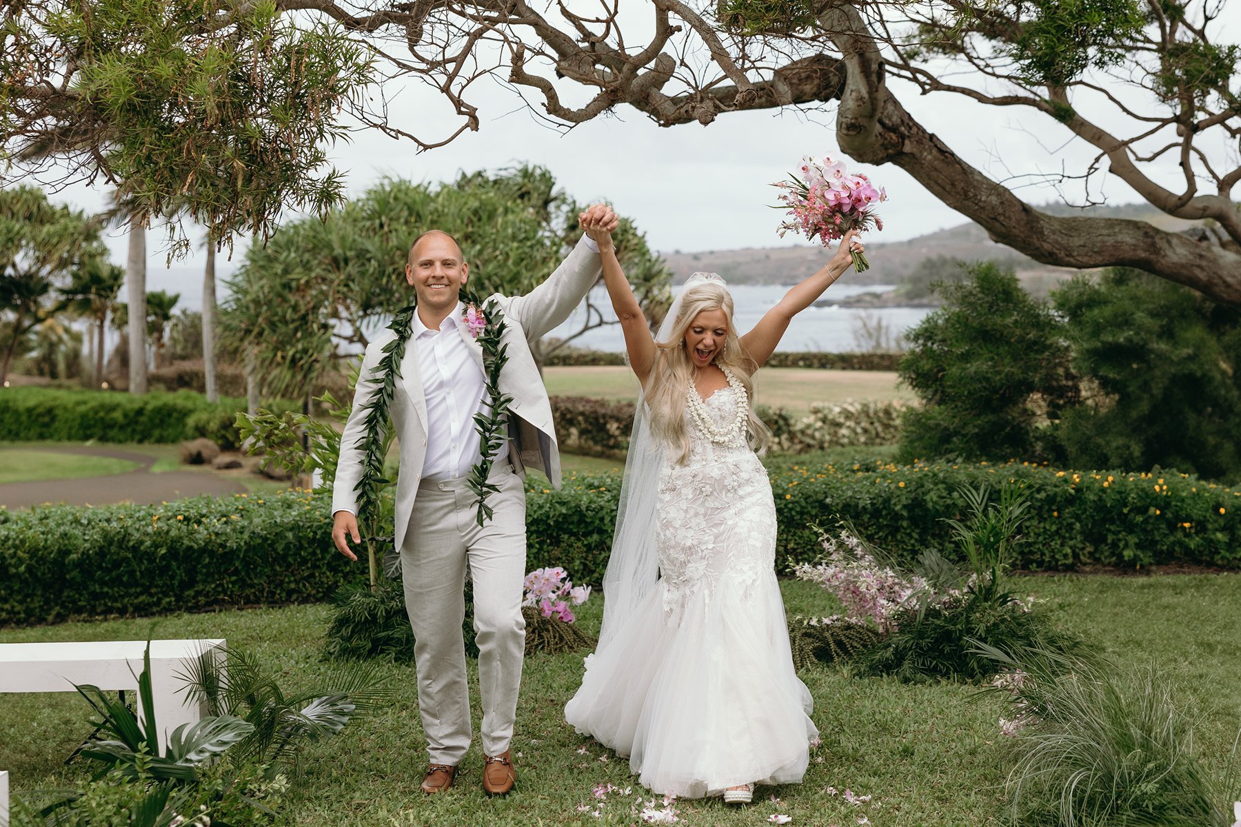 Bride and groom walking hand in hand down the aisle, celebrating their decision to elope in Maui with ocean views behind them.
