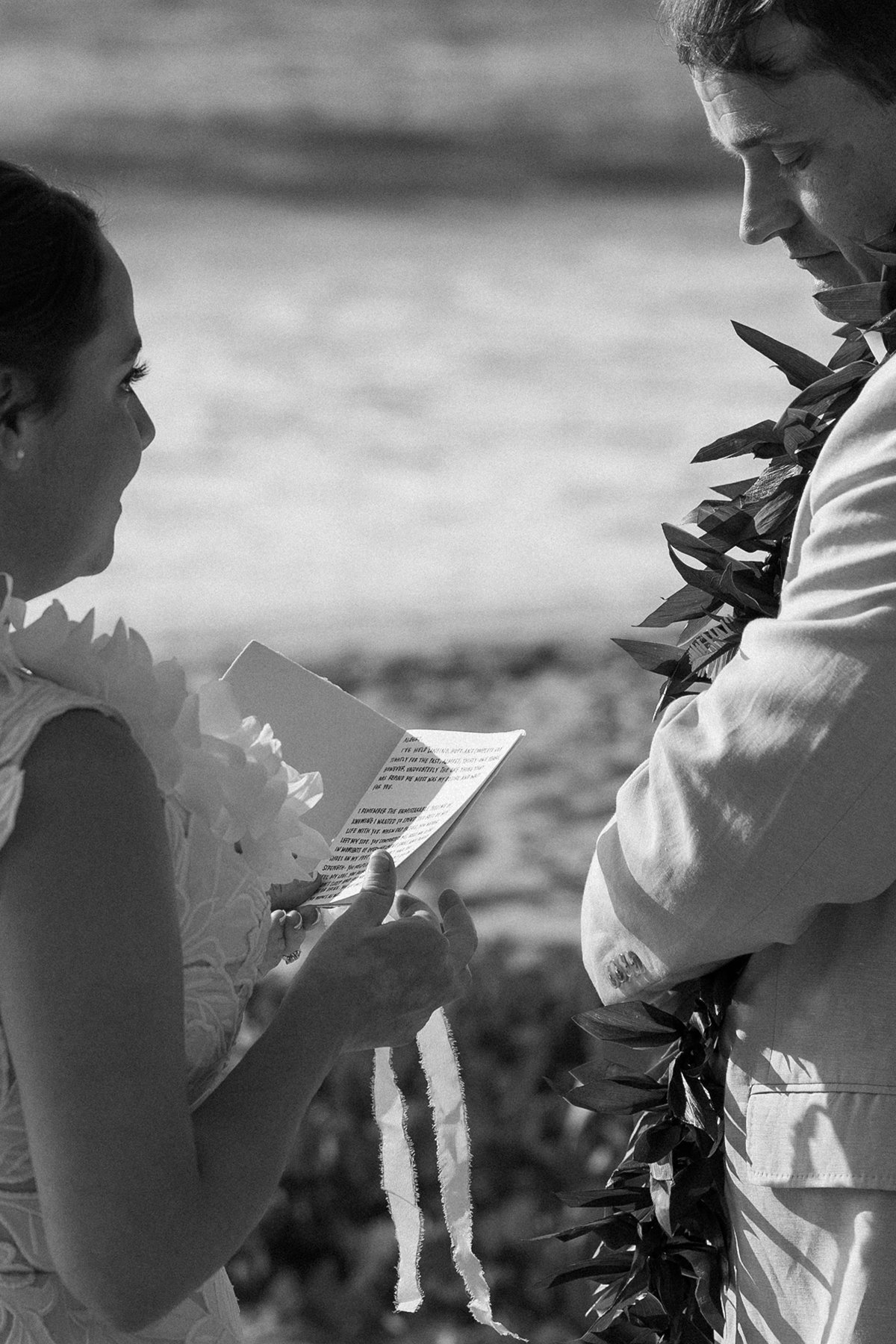 Bride reading handwritten vows to her groom during an intimate Maui beach elopement ceremony.