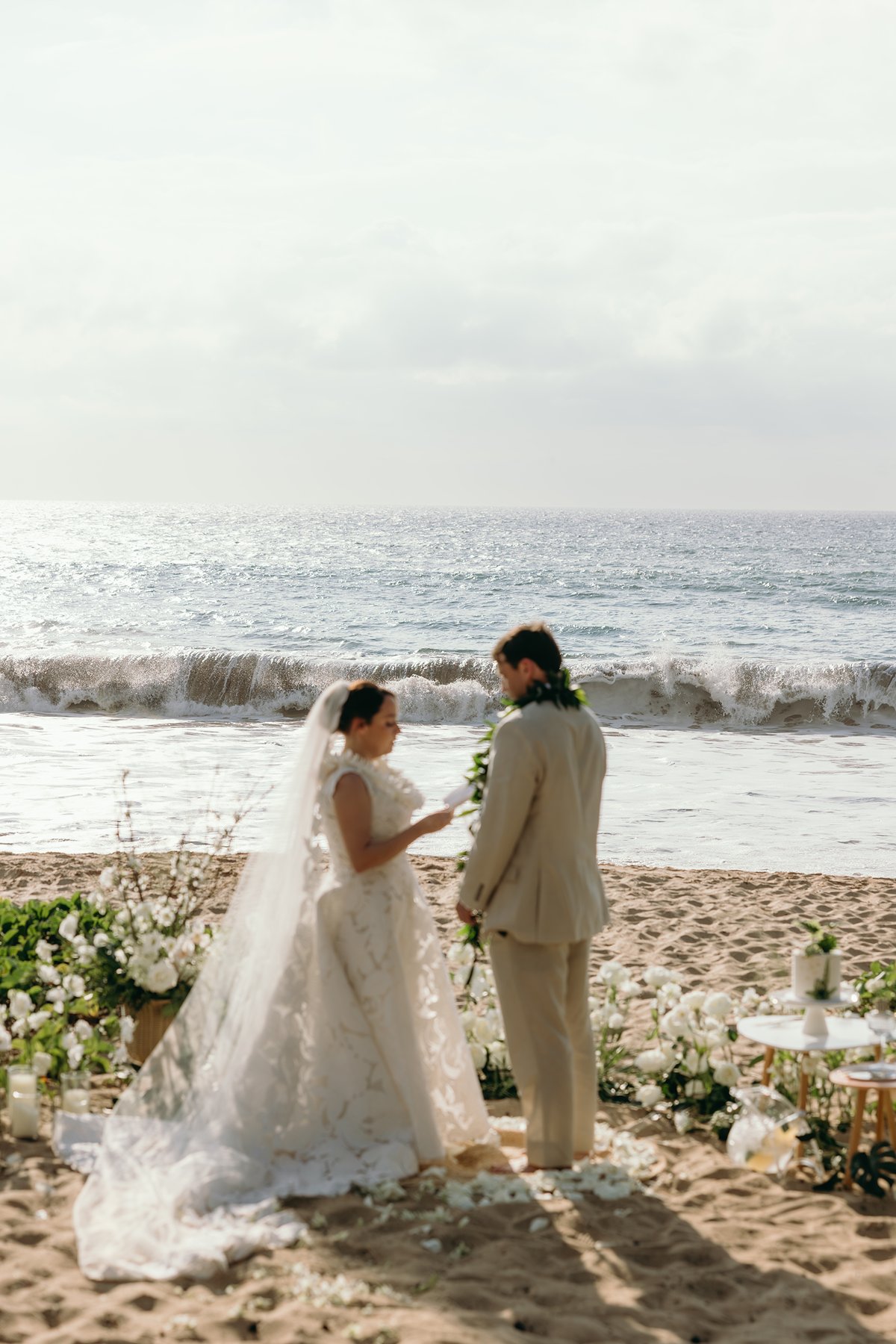 Couple standing together at their oceanfront ceremony space surrounded by tropical florals during Maui elopement photography.