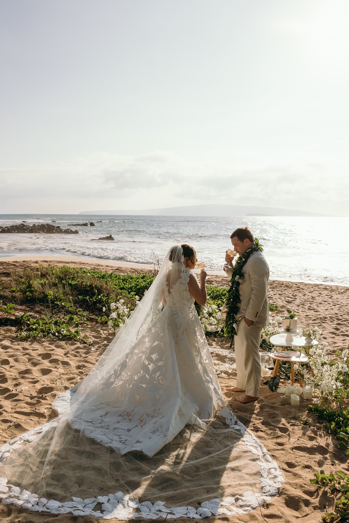 Couple standing together during their oceanfront ceremony surrounded by tropical florals and candles during elopement photography.