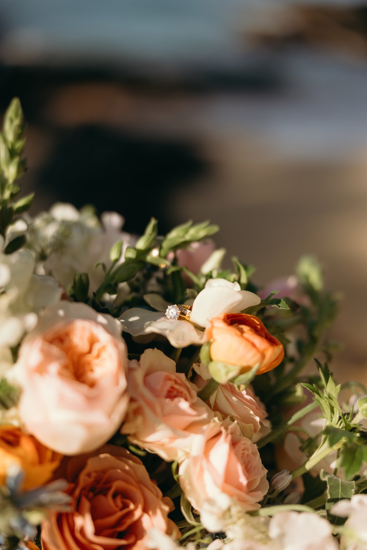 Close-up of wedding bouquet with engagement ring nestled in flowers in detail sneak peek photos