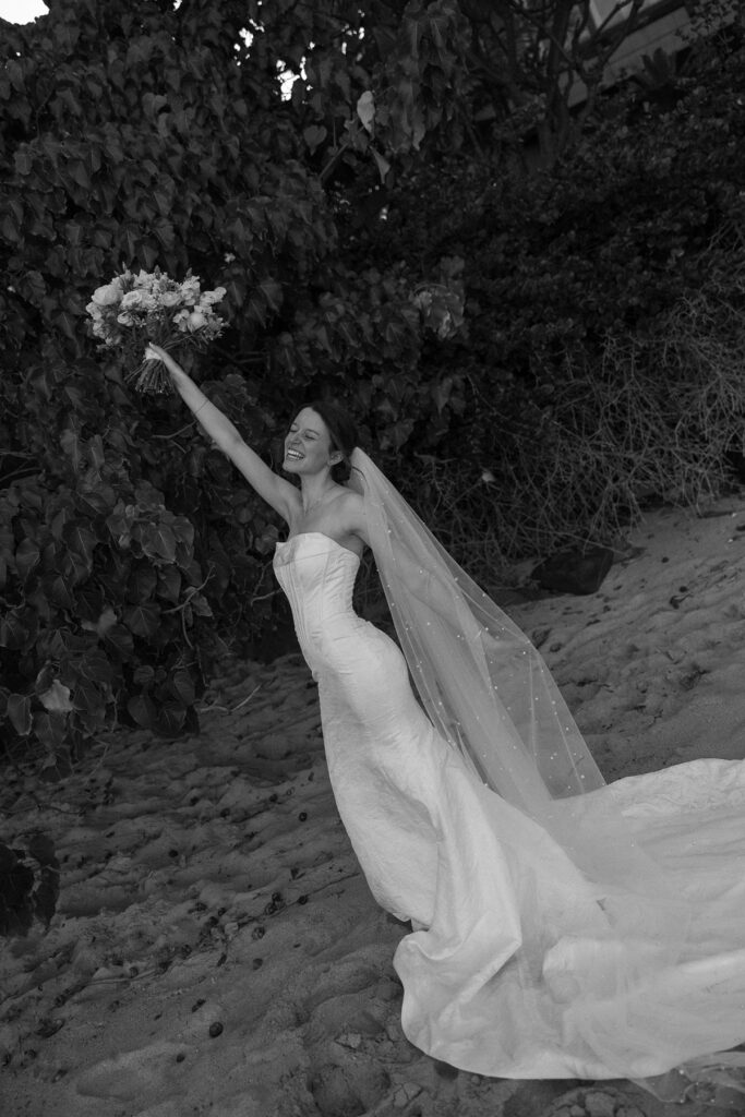 Black and white sneak peek photos of bride celebrating with bouquet against lush greenery