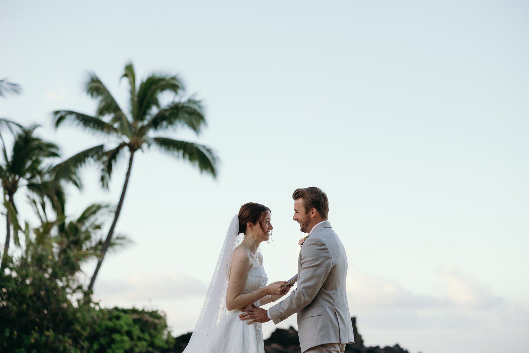 Bride and groom smiling during emotional vows on a tropical beach in wedding sneak peek photos