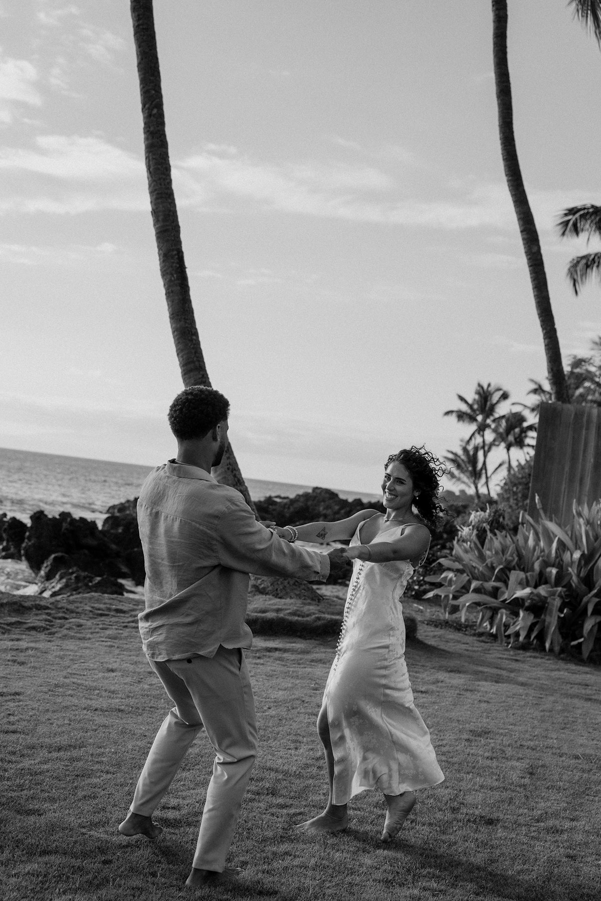 Black and white portrait of a couple dancing barefoot together during a relaxed Maui elopement
