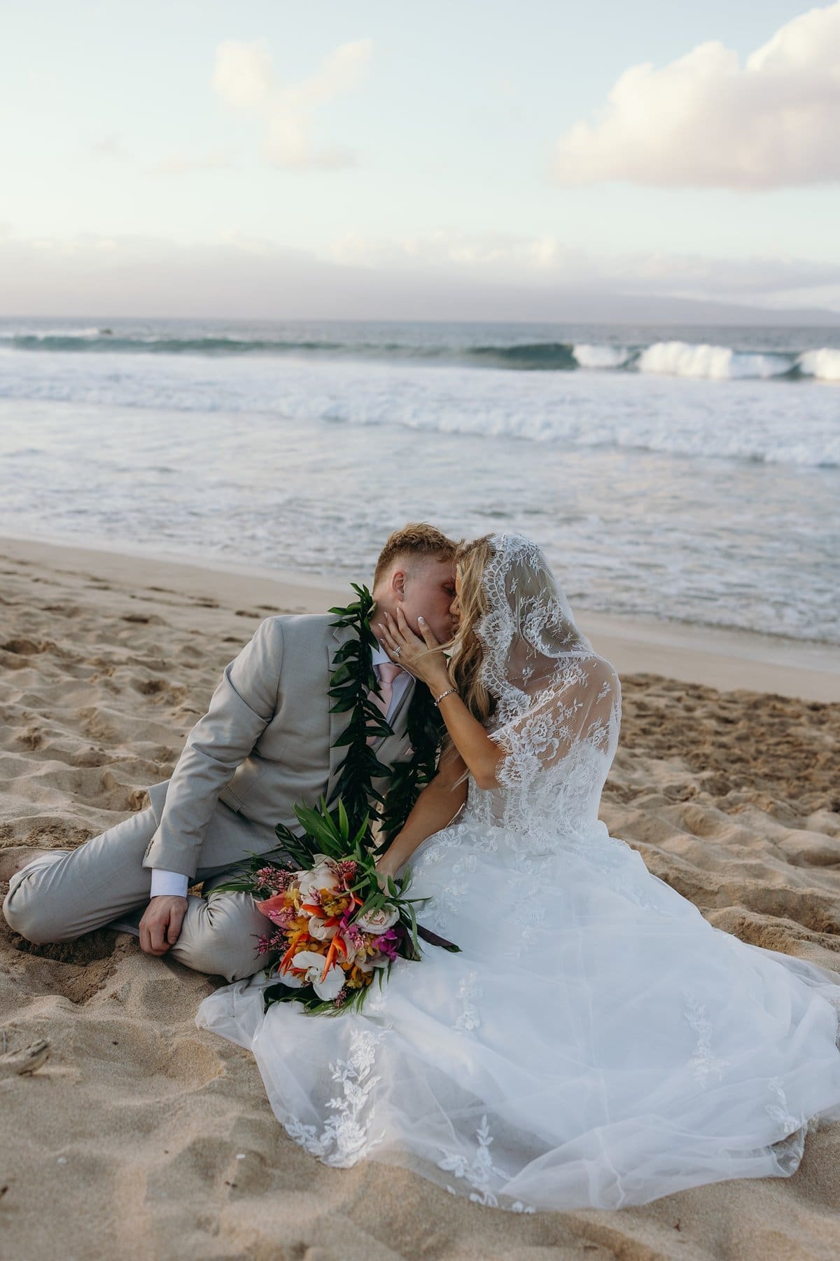 Bride and groom sharing a quiet kiss on the beach after their Maui elopement ceremony