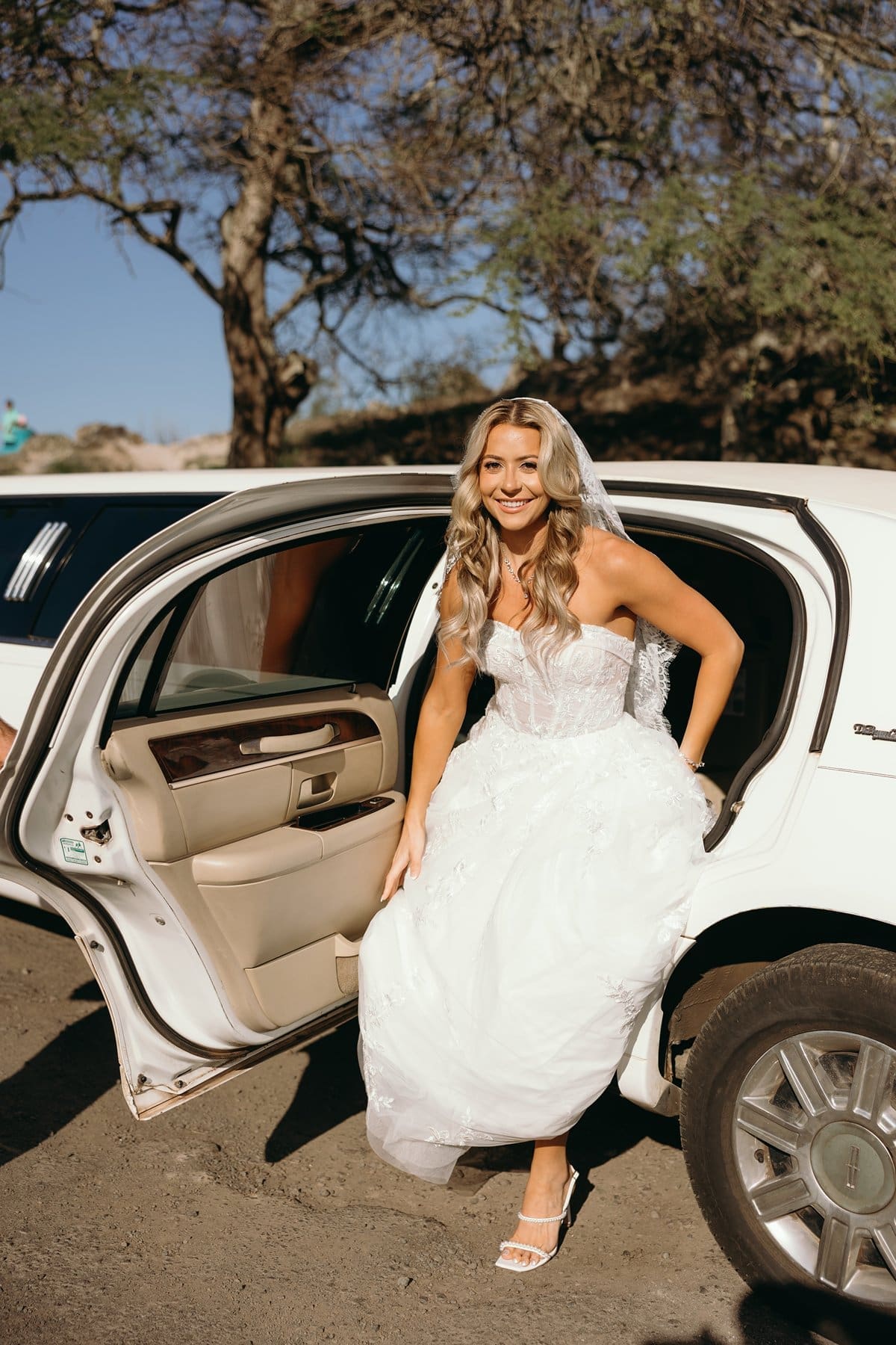 Newlyweds share champagne inside a limousine after celebrating their intimate beach wedding in Maui.