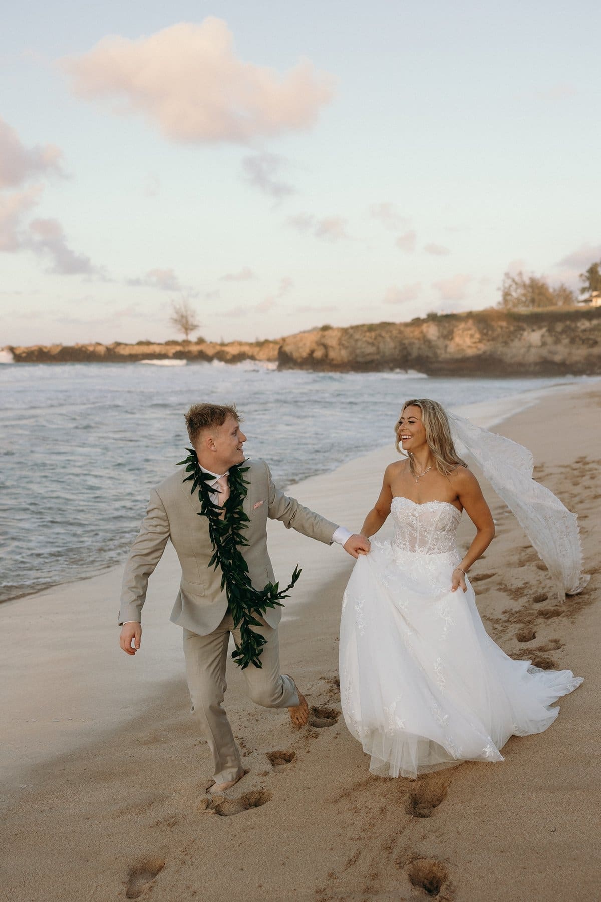 Bride and groom running barefoot along the shoreline after their Maui elopement ceremony at sunset
